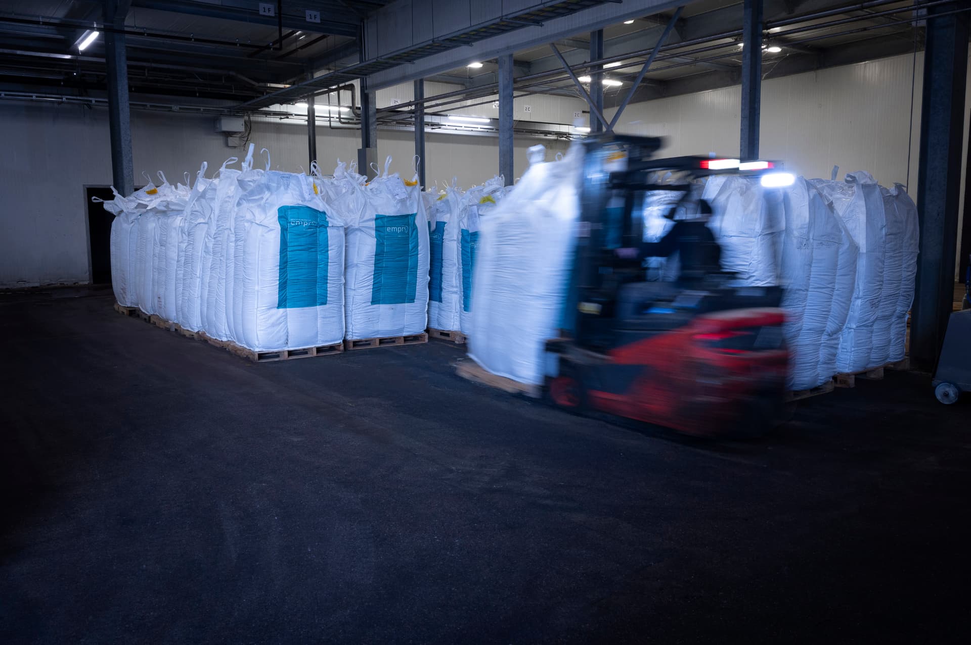 Forklift transporting Empro-branded big bags in the warehouse, ready for international shipment